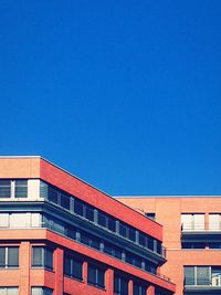 Low angle view of buildings against clear blue sky