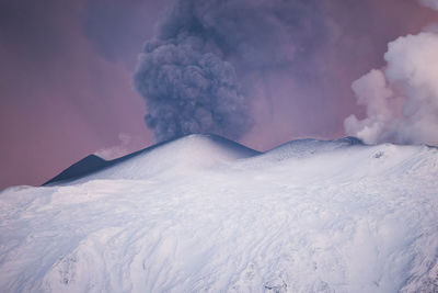 Scenic view of smoke emitting from volcanic crater during winter