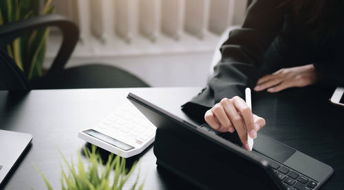 Midsection of man using laptop on table