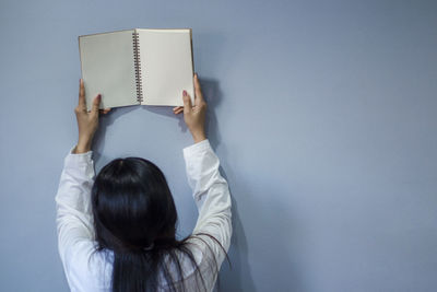 Rear view of woman reading book