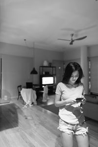 Woman looking at camera while standing at home