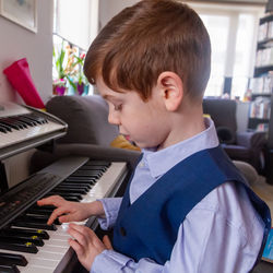  boy playing piano at home