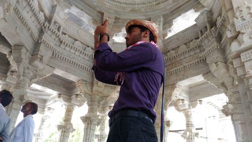 Low angle view of woman standing against built structure