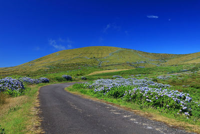 Scenic view of mountain road against blue sky