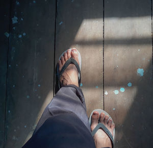 Low section of man standing on tiled floor