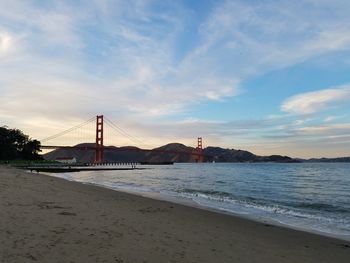 View of suspension bridge against cloudy sky