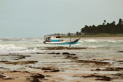 Boat on beach against clear sky