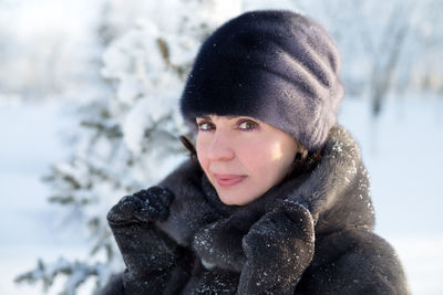 Portrait of a 40 year old woman in winter clothes on a background of snow.