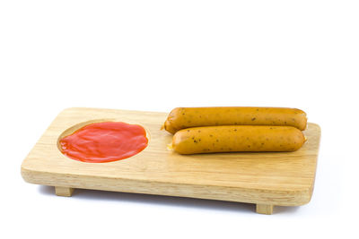 Close-up of cake on cutting board against white background