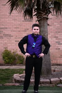 Portrait of young man standing against brick wall