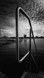 Railing by sea against sky