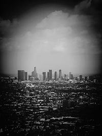 View of cityscape against cloudy sky