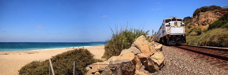 Train on beach against clear sky