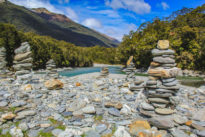 Stack of stones in water against sky