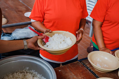 Midsection of woman serving food in bowls