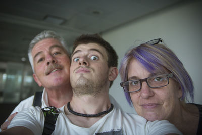 Close-up portrait of family against wall