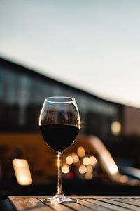 Close-up of wineglass on table against sky