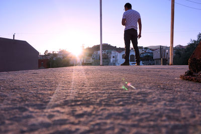 Low angle view of man standing on road against sky