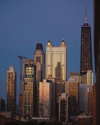 Skyscrapers in city against blue sky