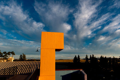 Modern built structure against cloudy blue sky