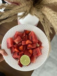 High angle view of hand holding fruits on table