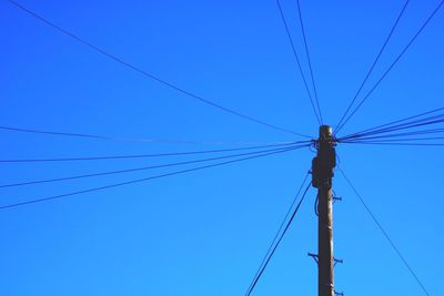 Low angle view of cables against blue sky