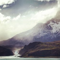 Scenic view of mountains against cloudy sky