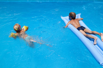 High angle view of friends swimming in pool