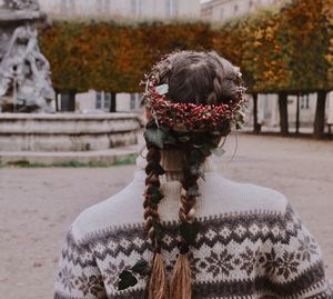 Rear view of young woman wearing wreath against autumn trees