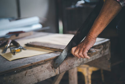 Cropped hand of man working on table