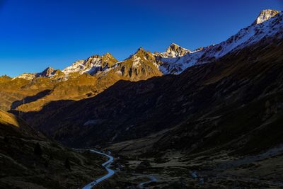 Scenic view of snowcapped mountains against clear blue sky