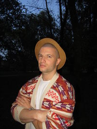 Portrait of young man standing against trees