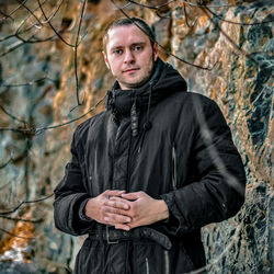 Portrait of young man standing in forest