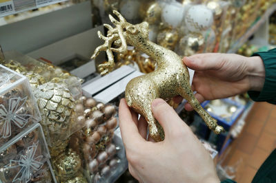 Cropped hand of man holding souvenir at store