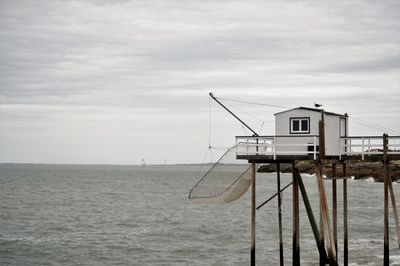 Lifeguard hut by sea against sky