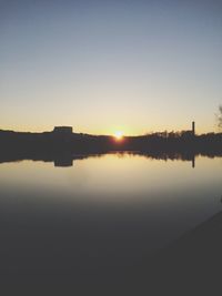 Scenic view of lake against clear sky during sunset