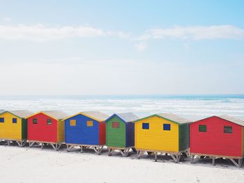 Beach huts by sea against sky