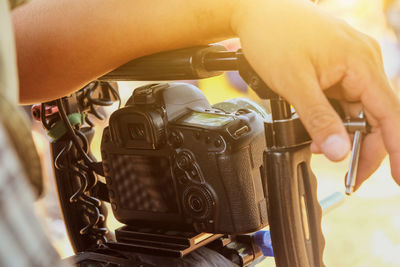 Cropped hand of man holding camera