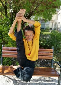 Portrait of a smiling young woman sitting on bench