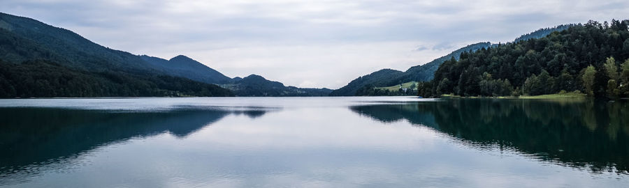 Scenic view of lake by mountains against sky