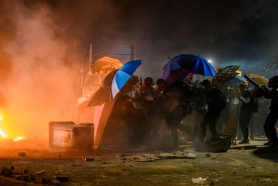 People protesting on street in city at night