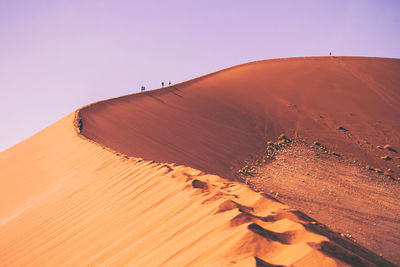 Sand dune in desert against clear sky