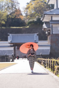 Woman walking by building in city