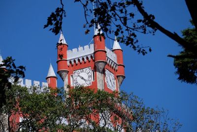 Low angle view of trees against clear blue sky