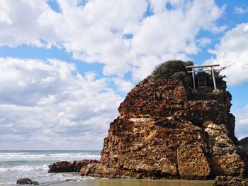 Low angle view of rock formation on sea against sky