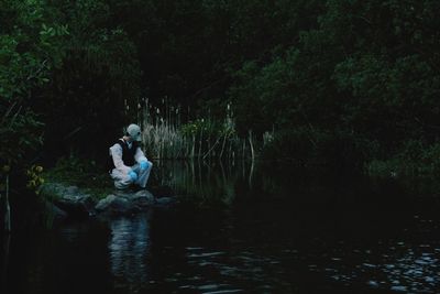 Woman looking at waterfall in forest