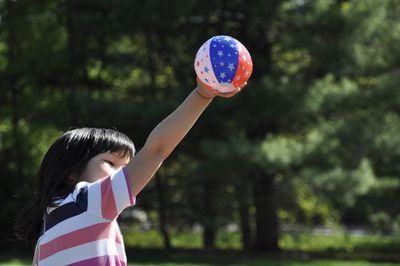 Side view of girl playing with ball