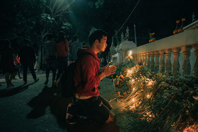 People by illuminated fire at night