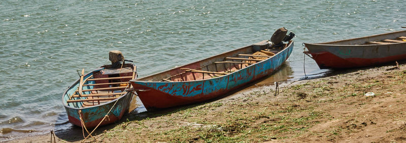 Blue fishing boats are moored on the banks of the nile river