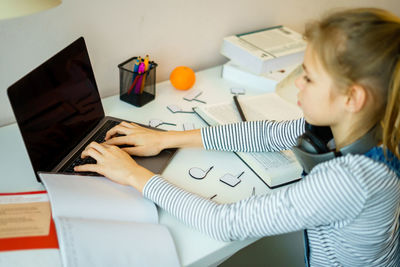 Midsection of woman using mobile phone while sitting on table